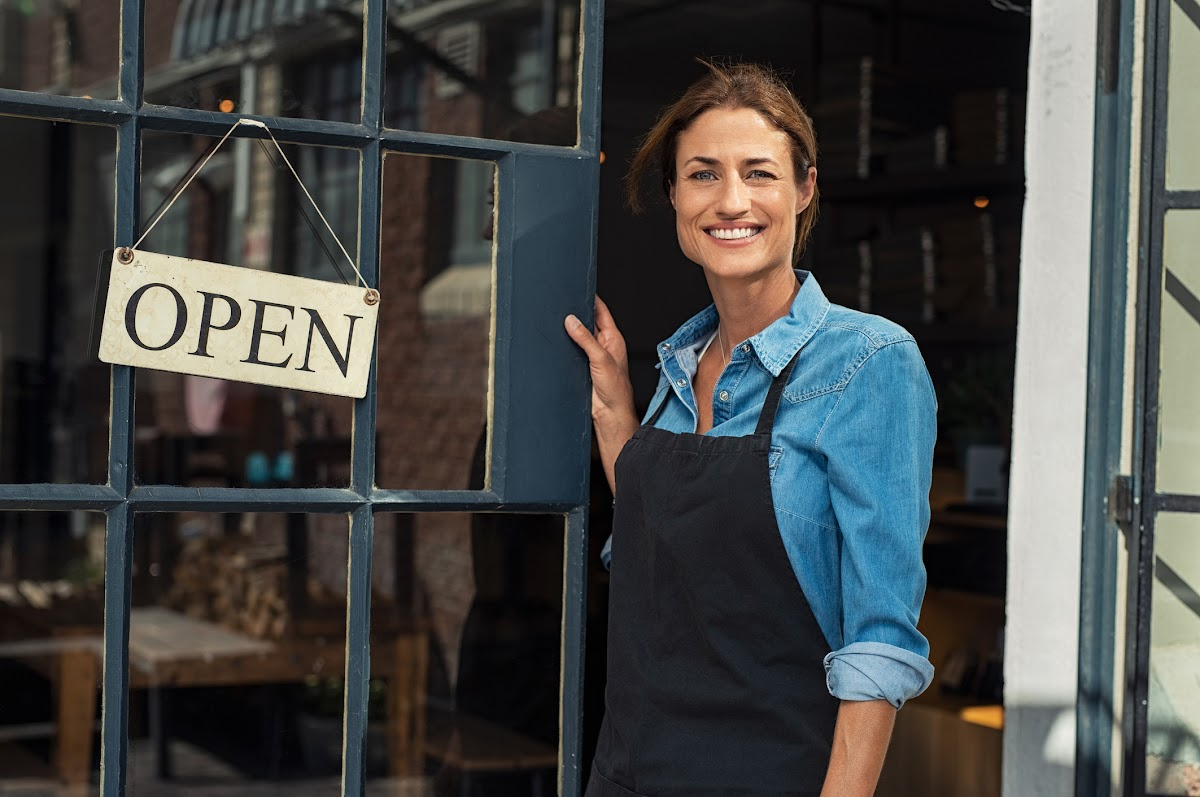 Smiling female business owner at the door of her shop in Fort Worth