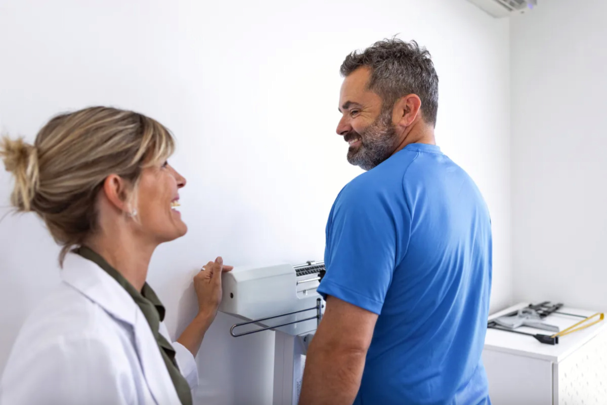 Man on a scale at a Fort Worth medical weight loss program check in