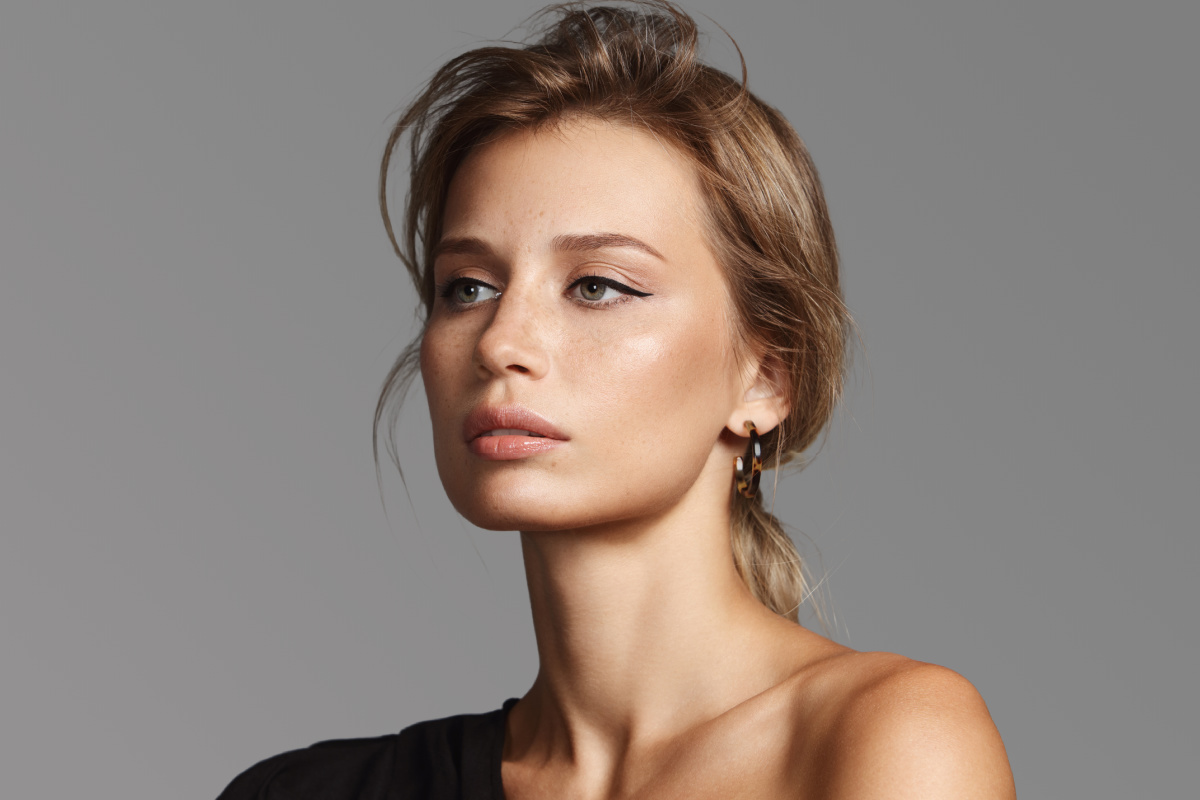 Young glamorous woman with winged eyeliner and lifted brows