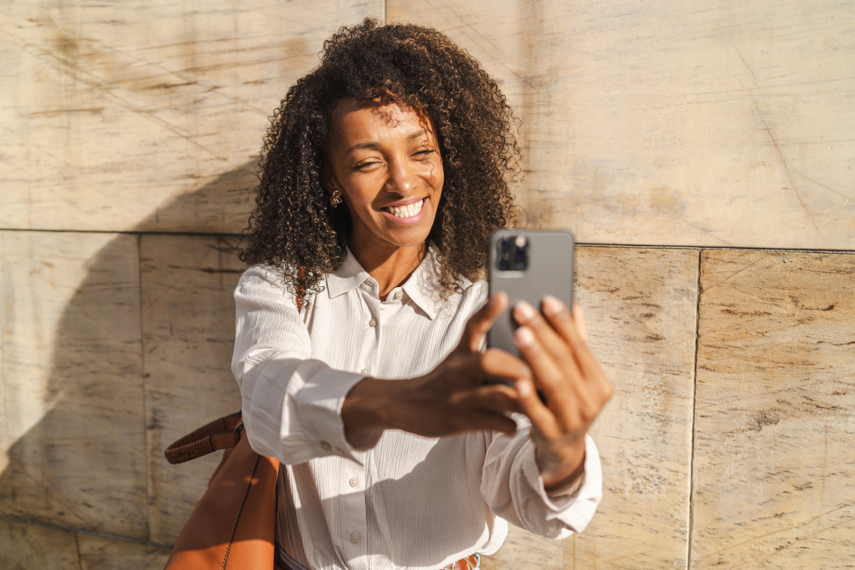 Young woman using a beauty filter on her phone taking a selfie