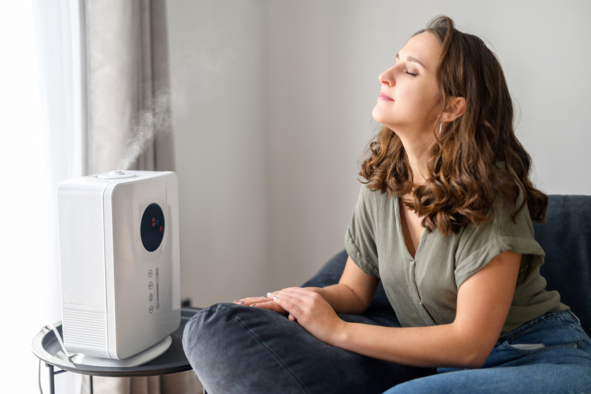 Woman using humidifier for skin benefits in winter