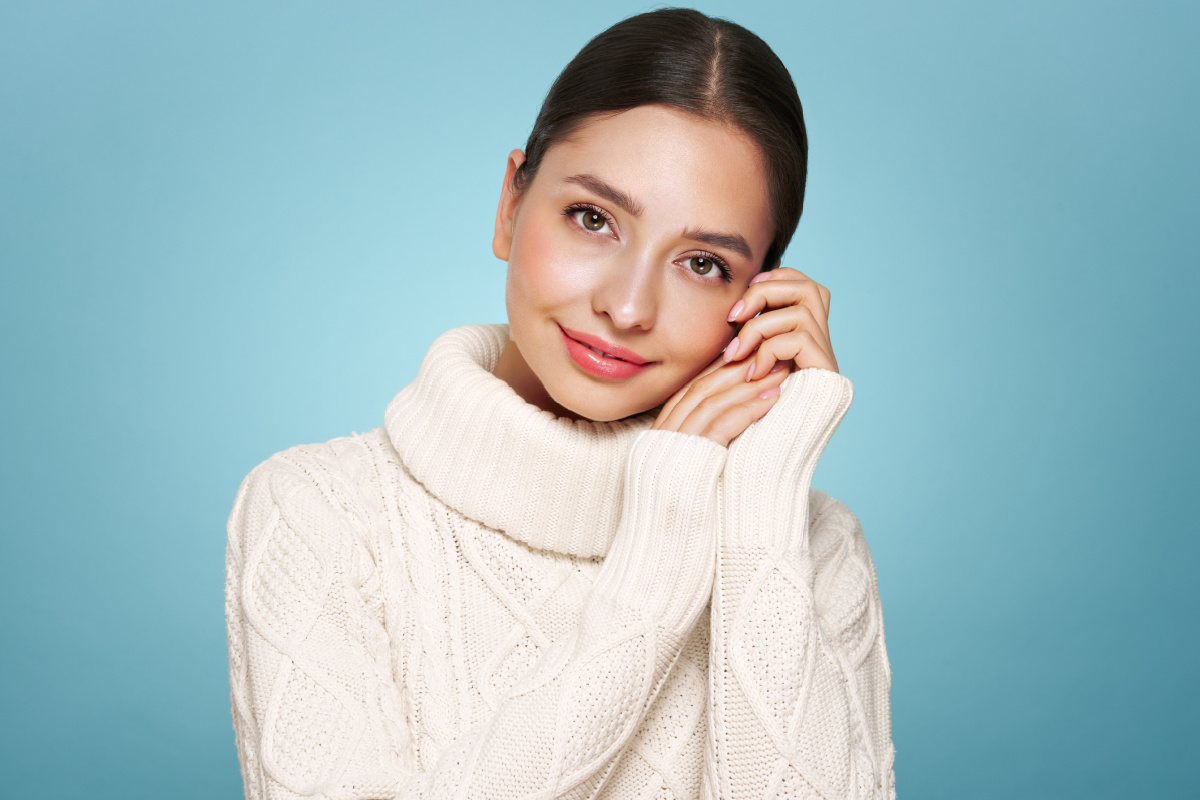Woman with glowing skin wearing white sweater